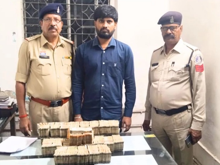 रायपुर में एक्टिवा से 75 लाख रुपए नकद बरामद करते पुलिस अधिकारी